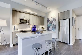 A kitchen with a white counter top and stainless steel appliances